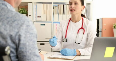 Female doctor consults patient sitting at desk in clinic. Man visits therapist for regular health checkup in medical center. Healthcare service
