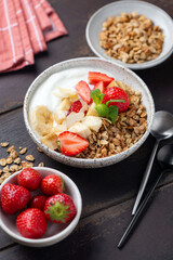 Strawberry granola bowl with yogurt, bananas. Healthy breakfast meal