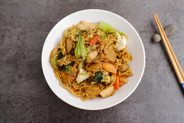 Bakmie Goreng or fried noodles. Served on white plate
