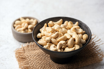 Group of cashew nuts in bowl on grey background