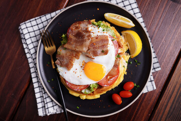 Fried Egg and Pork Waffles Food in a black plate on a wooden table