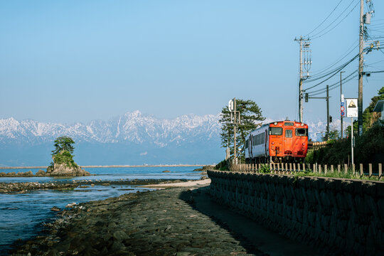 Local Train Passing Amaharashi Coast with Tateyama Mountains in the Background &ndash; Toyama, Japan, May 8, 2025
