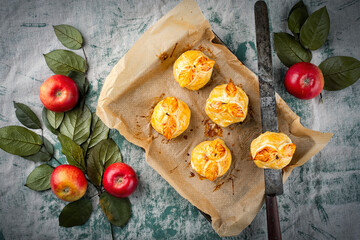 Traditional baked apples coated in pastry, decorated with pastry leaves and served as top view on a...