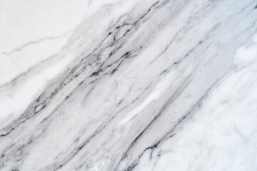 Detailed close-up reveals the intricate veins and subtle textures of white marble. Abstract natural backgrounds