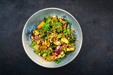 Authentical Thai mie goreng spicy stir-fried noodles with chicken and vegetables served as close-up in a Nordic design bowl
