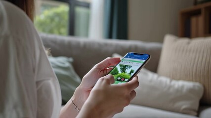 Woman browsing real estate listings on smartphone at home
