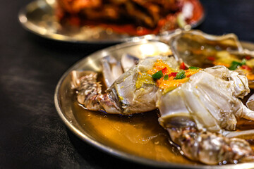 Korean Ganjang Gejang and Yangnyeom Gejang – Soy Sauce and Spicy Marinated Crab Duo. Vertical close-up showing two styles of Korean marinated crab: Ganjang Gejang (soy sauce marinated raw crab).