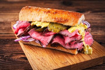 Traditional sliced cold cuts roast beef sandwich with onion, gherkin and onion