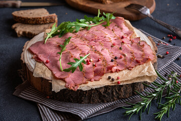 Sliced pastrami meat with rosemary and pepper