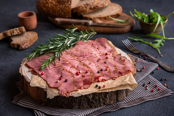 Sliced pastrami meat with rosemary and pepper