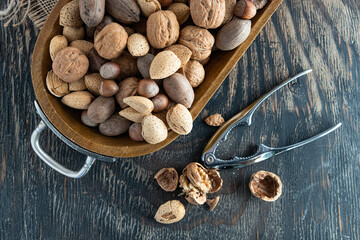 Assorted raw nuts on wooden table with nutcracker