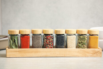 Different aromatic spices in jars on light table