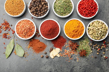 Different aromatic spices on grey table, flat lay