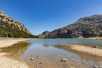 A high altitude dry lake on the Spanish island of Mallorca with green mountains and blue sky