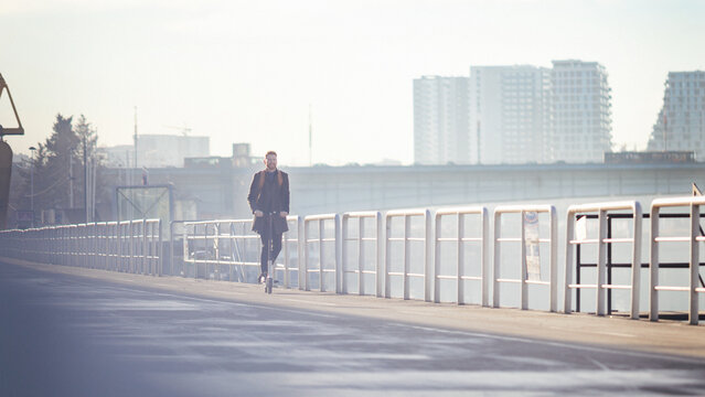 Young businessman on e scooter in the city