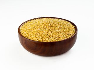 Indian yellow lentils called Moong Dal in wooden bowl isolated on white background