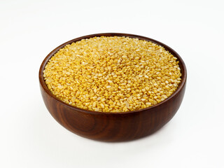 Indian yellow lentils called Moong Dal in wooden bowl isolated on white background 