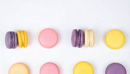 Obraz premium the image features a collection of circular treats arranged neatly on a clean, bright surface. the sweets display an array of pastel colors, including pink, yellow, and purple hues