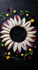 Squid Tubes Arranged in a Circular Pattern with Decorative Edible Elements on Dark Background