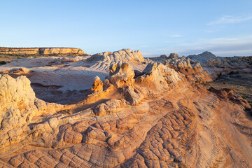 White Pocket at Vermillion Cliffs in Northern Arizona.  White sandstone calcium deposit rocks scattered over the dry desert landscape.  Photographed at sunset.