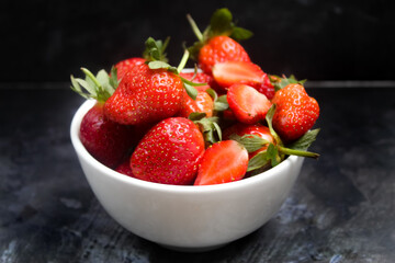 bowl of strawberries on black background