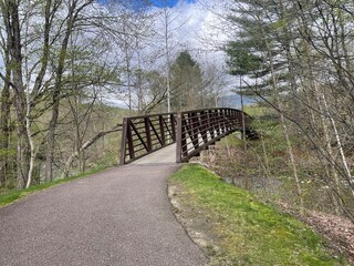 A walking bridge crosses a river in the Vermont countryside