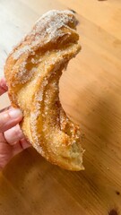 Hand clutches sugar-sprinkled churro, evoking carnival whispers, crispy delights of Dia de los...