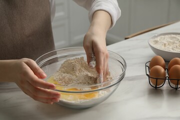 Making khinkali. Woman mixing dough at table in kitchen, closeup
