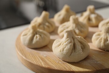 Many uncooked khinkali on countertop indoors, closeup
