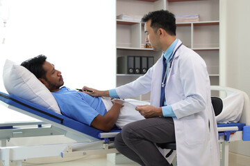 Doctor attending patient lying in hospital bed. Doctor visits patient in hospital room.