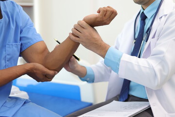 Doctor checking patient's pulse in hospital room.