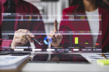 Businesspeople analyzing financial data displayed on a futuristic transparent screen, the integration of technology in modern finance.