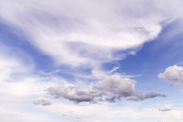 Beautiful light blue sky with many white cirrus and fluffy clouds in sunlight, background texture, heaven