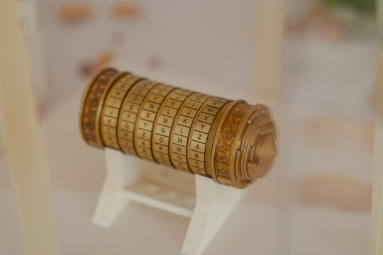 Cryptex resting on white stand showing alphabet letters, concept of encryption and security