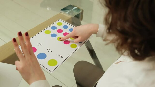 Woman practicing neurogymnastics exercise with colored circles to stimulate brain activity and coordination.