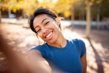 Close-up selfie of a young woman smiling in the sunshine
