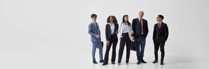 Banner. Group of professionals, male and female, posing together showcasing confidence against white studio background with negative space. Concept of business and policy, confidence, communication