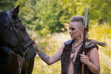 Obraz premium Warrior interacts with horse in natural setting during sunny afternoon