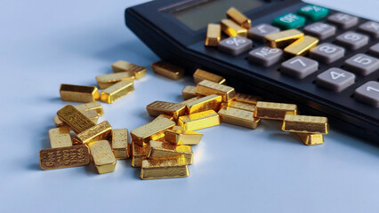 Gold Bar Placed on Calculator Representing Wealth, Investment, and Financial Calculation