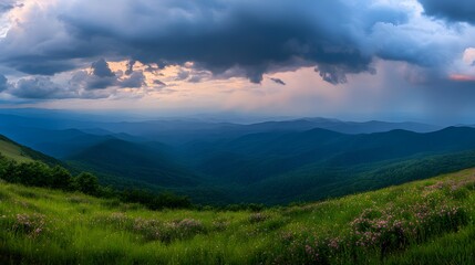 Fototapeta premium Vast mountain range under dramatic sky at sunset.