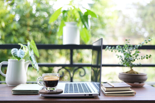 chilling balcony workspace with coffee drink and laptop side view