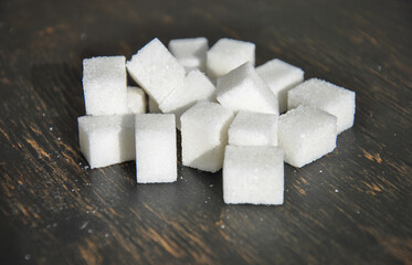 refined sugar on a dark wooden background. white sugar cubes on a dark background.