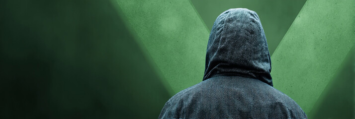 Dark-hooded figure against emerald light, veiled mystery, enigmatic contemplation, Cybersecurity Awareness Week, elusive digital frontier exploration