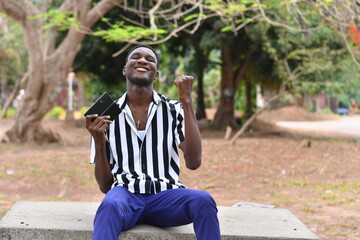 Fototapeta premium Handsome african american man outdoors using smart phone