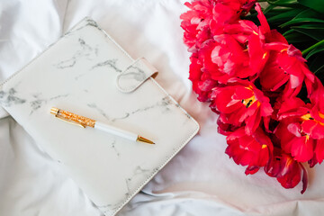 Elegant planner and fresh flowers create a stylish workspace arrangement