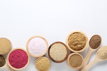 Different superfood powders in bowls and spoons on white background, flat lay. Space for text