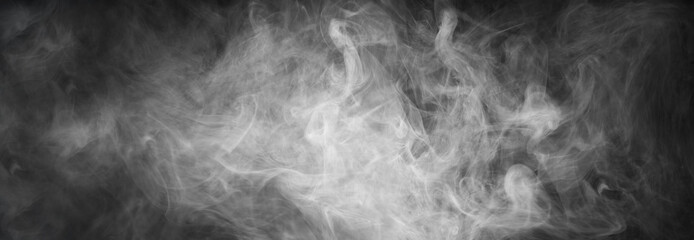 Abstract smoke texture over black background. Fog in the darkness.