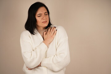 Her facial expression and posture convey a clear sense of unease. This gesture emphasizes physical...