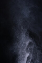 Abstract smoke texture over black background. Fog in the darkness.
