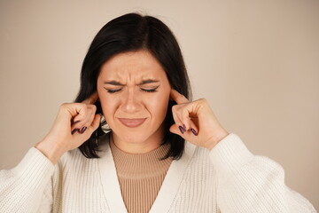 It's a natural reaction to overwhelming sound. The person covers their ears with their palms, attempting to block out unwanted noise. This gesture conveys a desire to avoid unpleasant information.